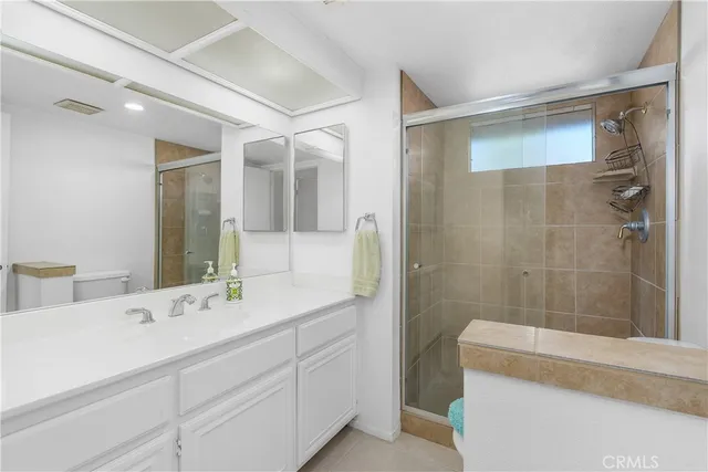 a bathroom with a double vanity sink mirror and shower