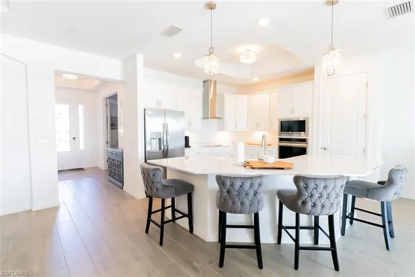 a view of a dining room and livingroom with furniture wooden floor a chandelier