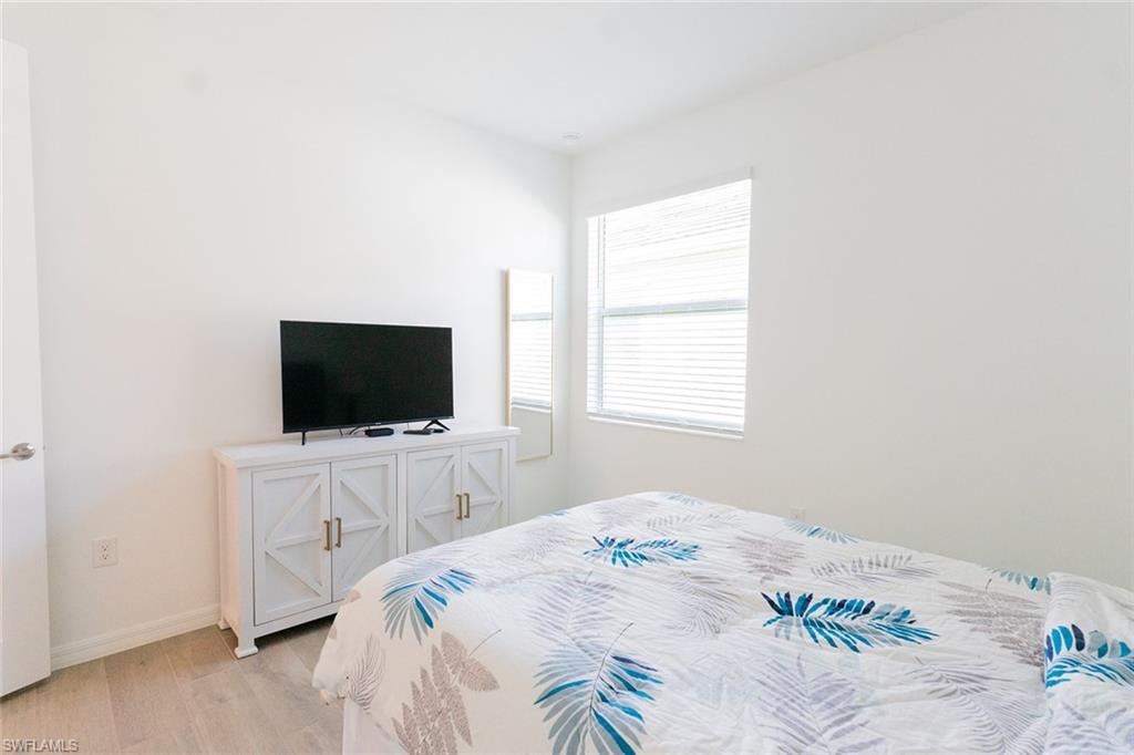 5534 Hampton Links Court Ave Maria, FL 34142 - Photo 17 of 50 a bedroom with a bed and a flat screen tv