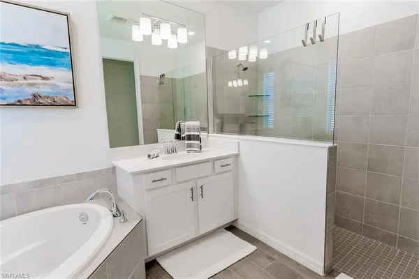 a bathroom with a tub sink and mirror