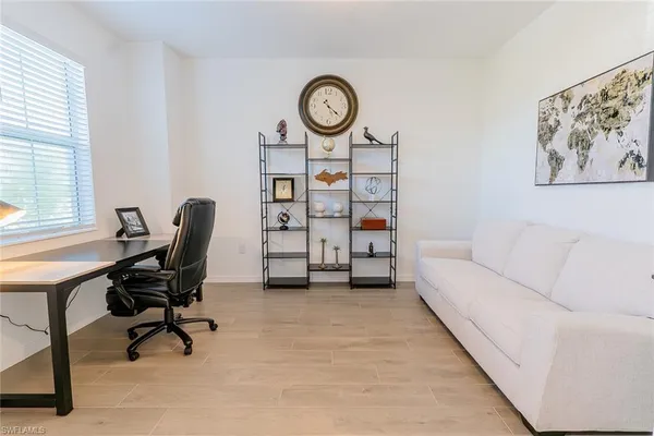 a view of a workspace with furniture and a window