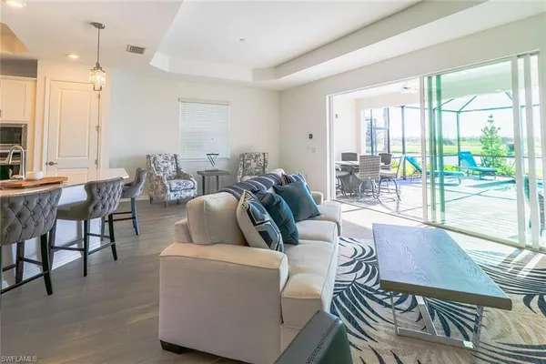 a living room with furniture a large window and wooden floor