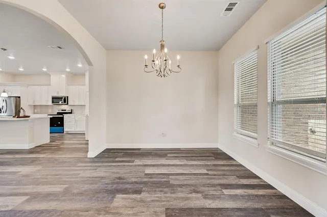 a view of a livingroom with a chandelier furniture and windows