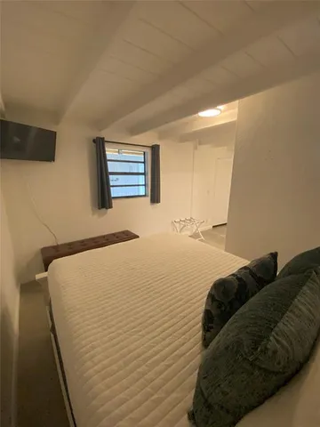 a bed sitting in a bedroom next to a window