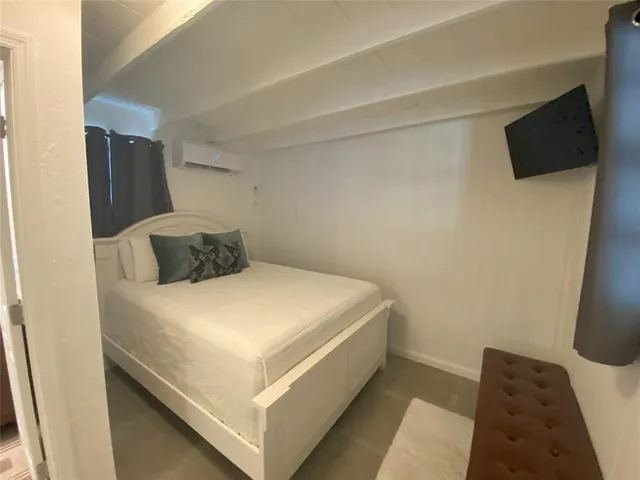 a bedroom with a bed and flat screen tv