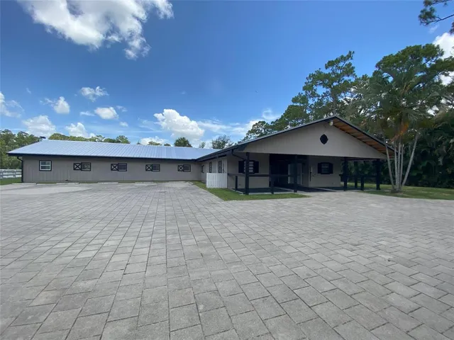 a view of a house with a yard and large tree