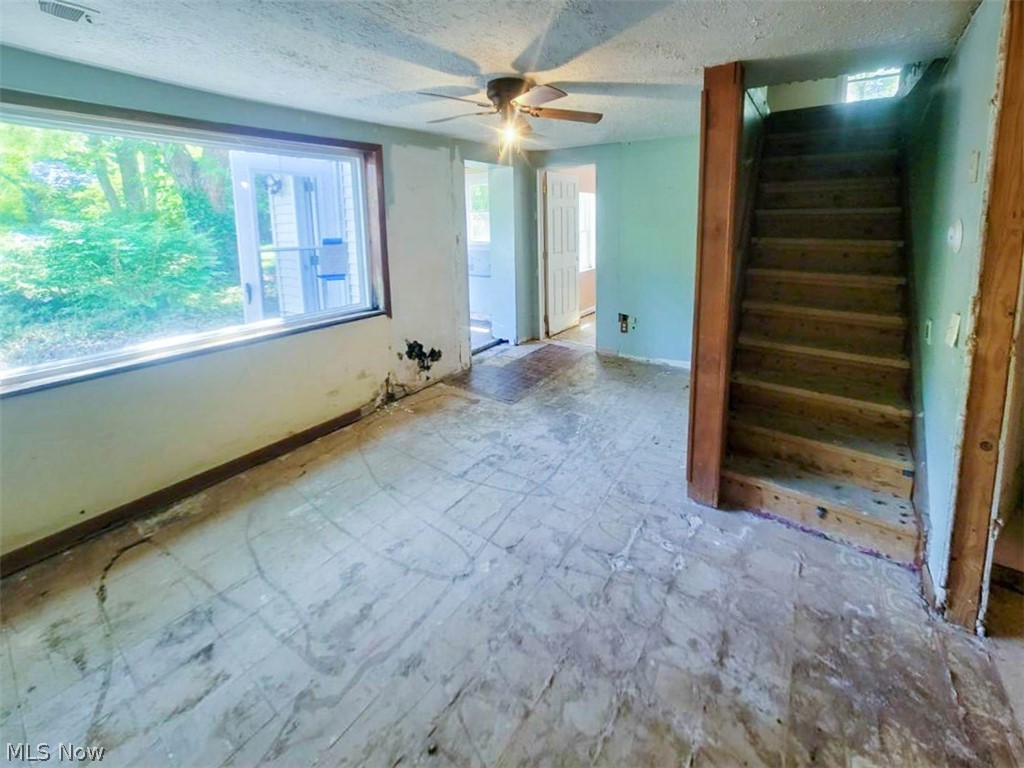 109 Harper Road Streetsboro, OH 44241 - Photo 6 of 28 Empty room featuring ceiling fan, tile flooring, and a wealth of natural light