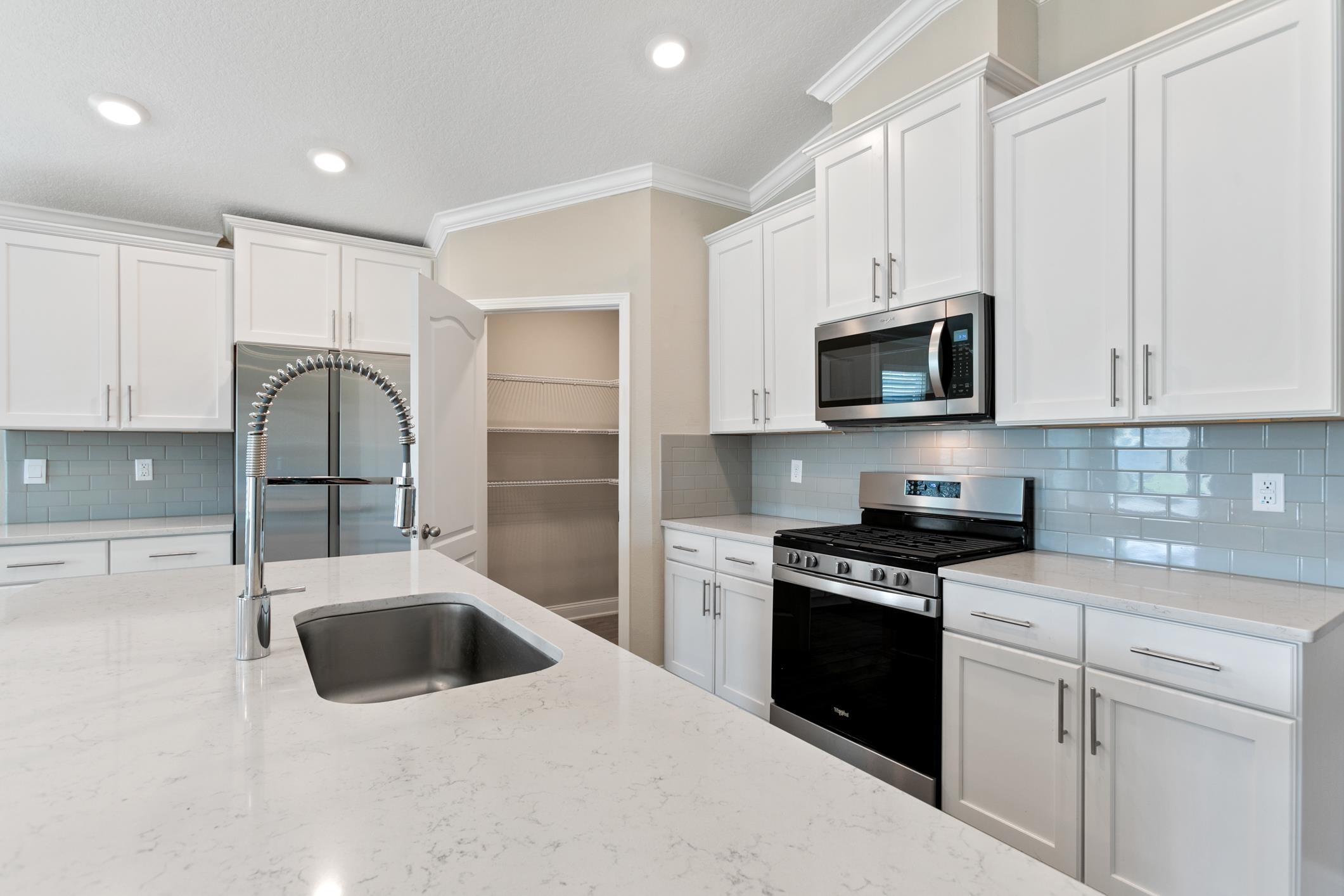 42 Huesca Court St. Augustine, FL 32084 - Photo 11 of 70 a kitchen with stainless steel appliances kitchen island granite countertop a stove a sink and a microwave