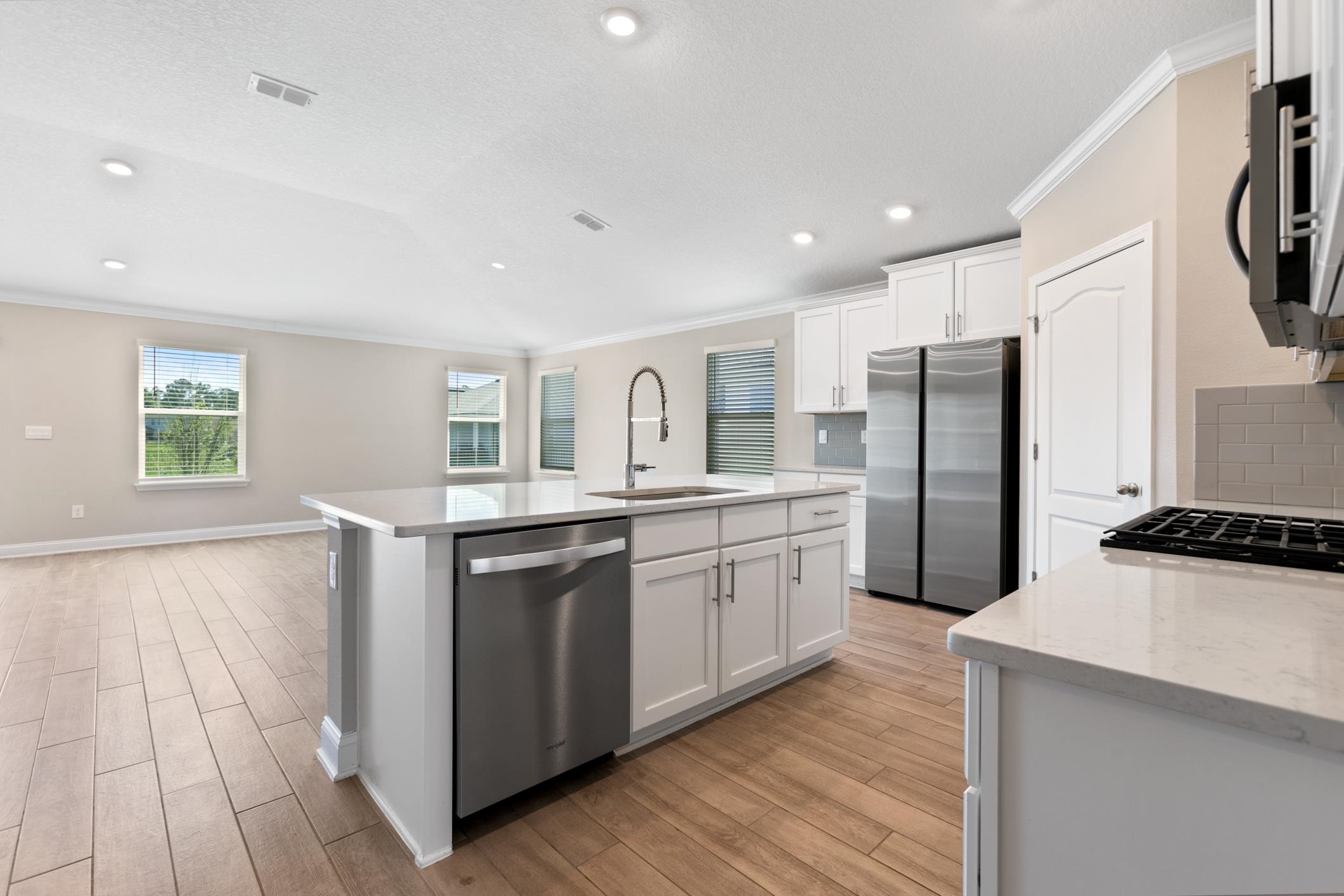 42 Huesca Court St. Augustine, FL 32084 - Photo 17 of 70 a kitchen with stainless steel appliances granite countertop a refrigerator a sink dishwasher a oven with white cabinets and wooden floor