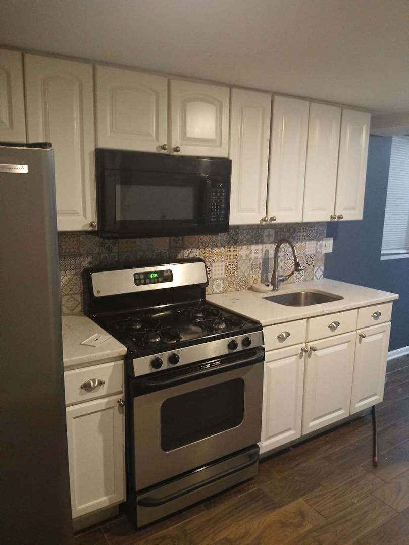 1014 West 19th Street, Unit G Chicago, IL 60608 - Photo 2 of 3 a kitchen with white cabinets and appliances