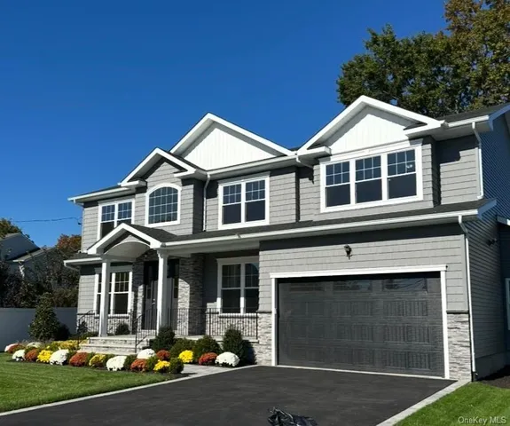 a front view of a house with yard and garage