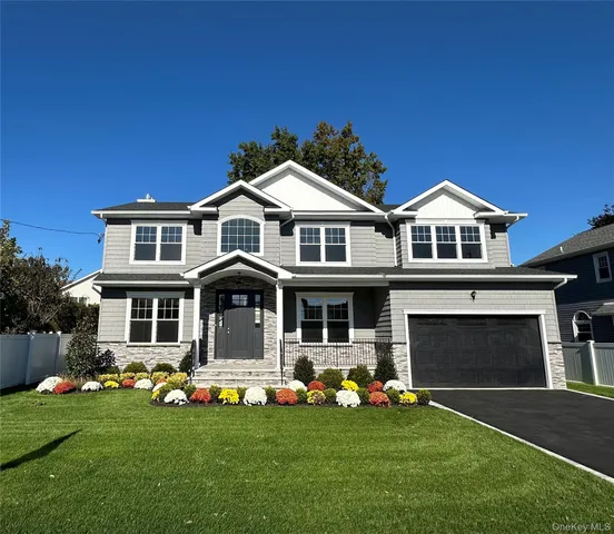 a front view of a house with a garden and yard