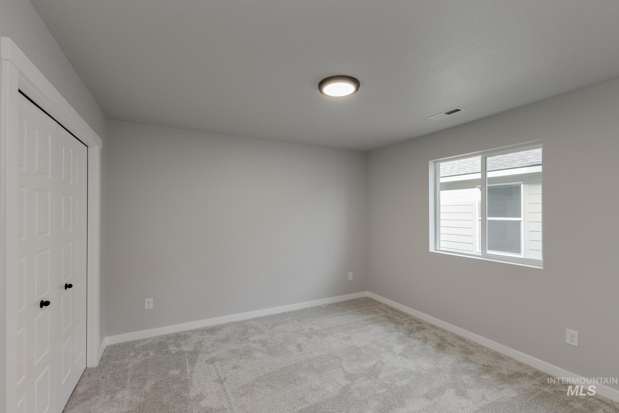 907 North Aleppo Way Meridian, ID 83642 - Photo 12 of 19 Unfurnished bedroom with light colored carpet and a closet
