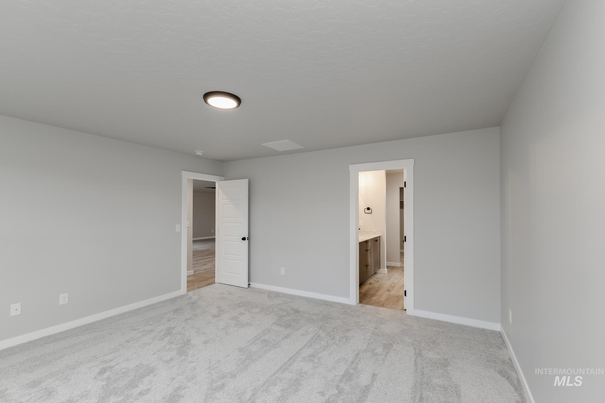 907 North Aleppo Way Meridian, ID 83642 - Photo 17 of 19 Unfurnished bedroom featuring light colored carpet and connected bathroom