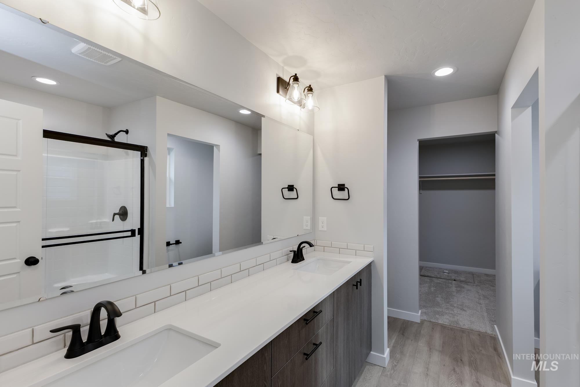 907 North Aleppo Way Meridian, ID 83642 - Photo 18 of 19 Full bath with recessed lighting, a shower stall, double vanity, light wood finished floors, and a spacious closet