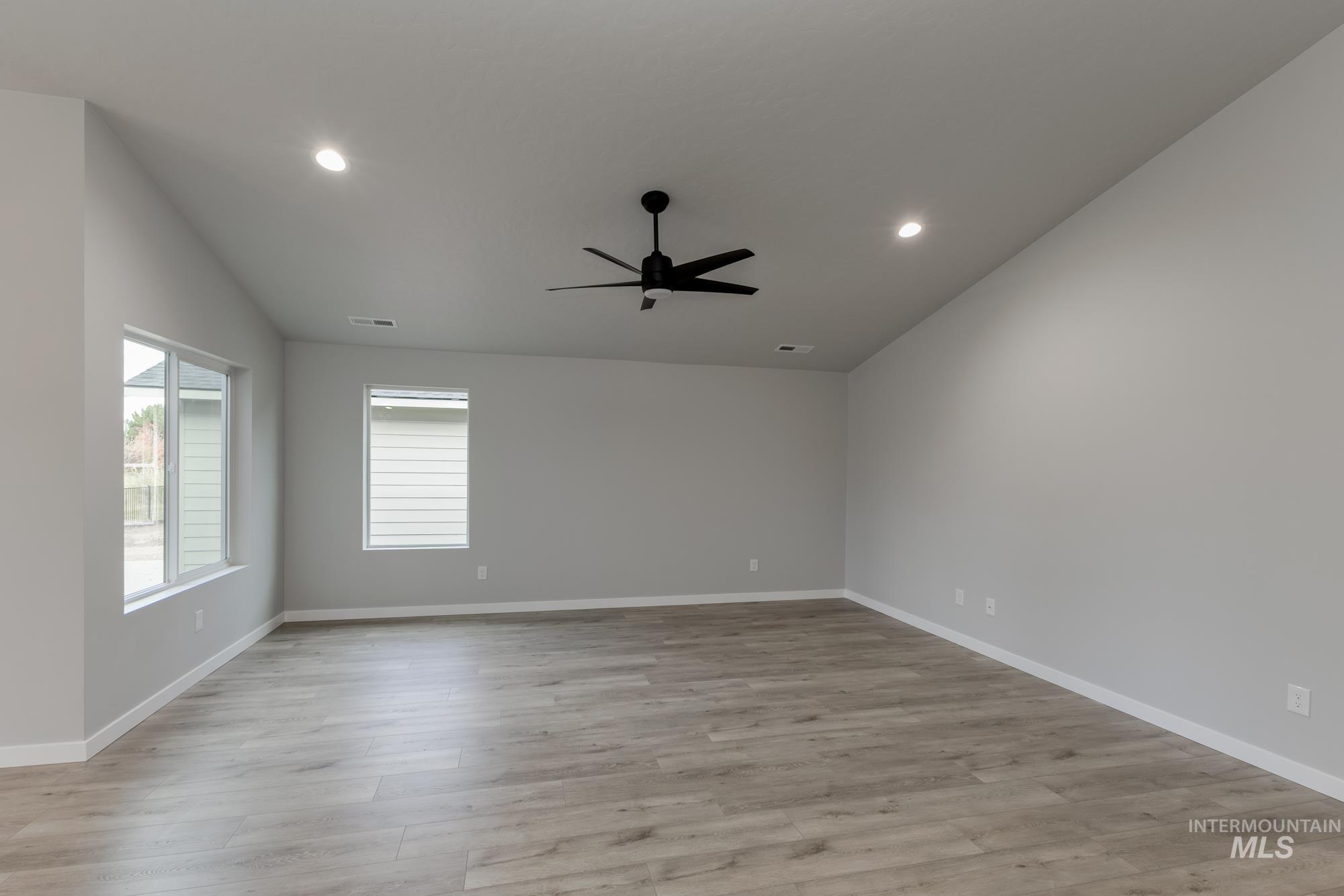 907 North Aleppo Way Meridian, ID 83642 - Photo 7 of 19 Spare room with light wood-style floors, recessed lighting, a ceiling fan, and vaulted ceiling