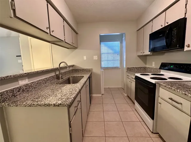 a kitchen with stainless steel appliances granite countertop a sink a stove and a microwave