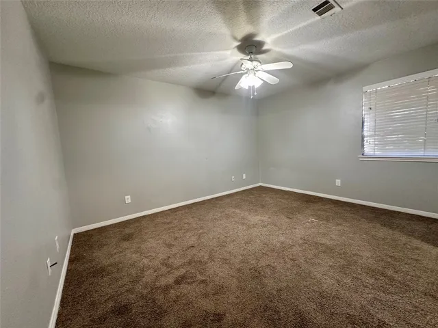 an empty room with a chandelier fan