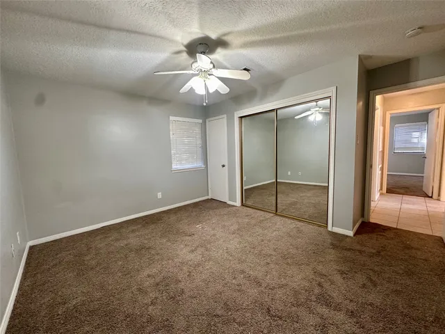 a view of an empty room with a chandelier fan