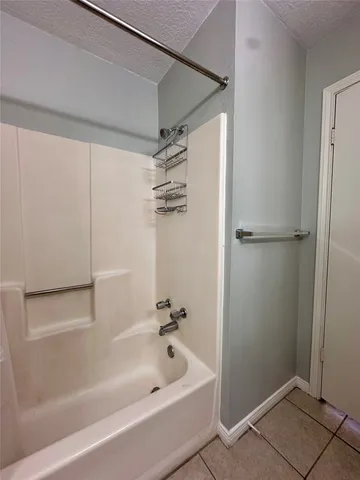 a white bath tub sitting next to a shower