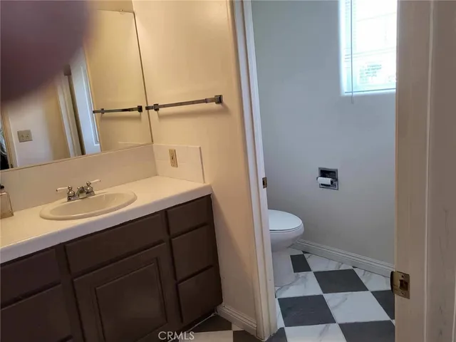 a bathroom with a sink a toilet a mirror and shower
