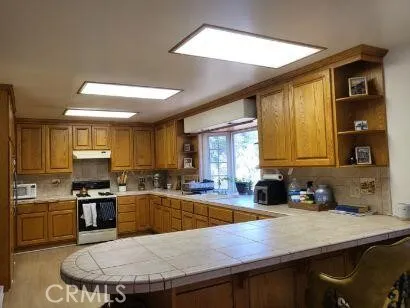 a kitchen with stainless steel appliances granite countertop a refrigerator sink stove microwave and cabinets