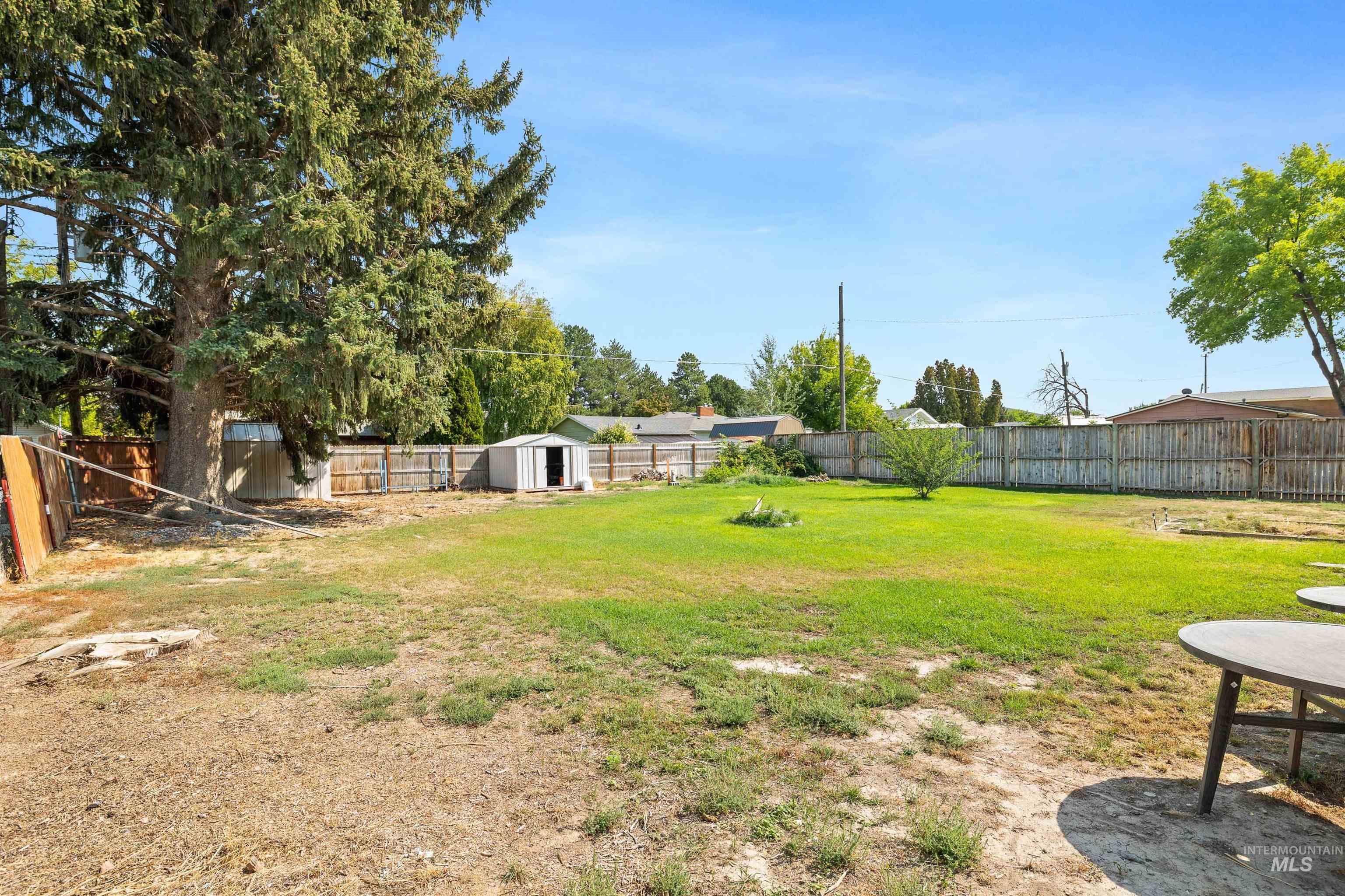 817 Union Avenue Filer, ID 83328 - Photo 23 of 37 Fenced backyard with a storage unit and a patio area