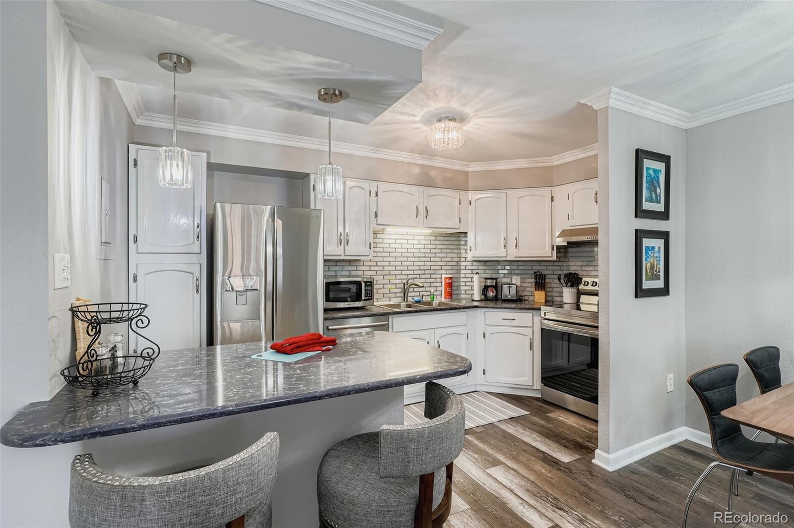 1625 Larimer Street, Unit 602 Denver, CO 80202 - Photo 6 of 22 a kitchen with granite countertop a sink cabinets and stainless steel appliances
