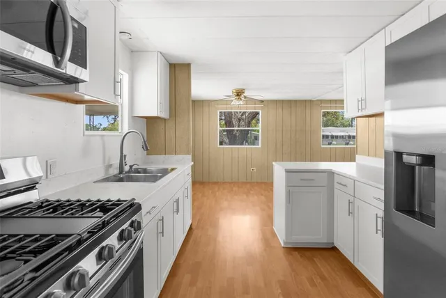 a kitchen with a stove a sink and wooden floor