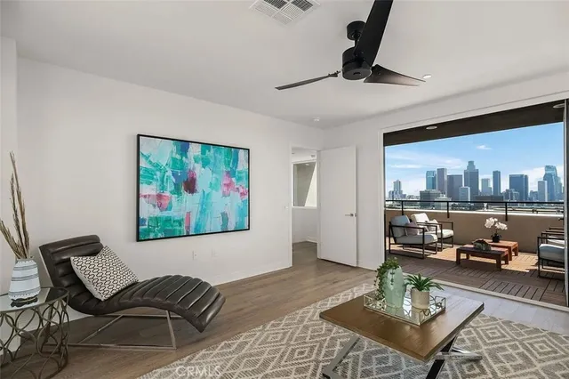 a living room with furniture and a view of kitchen