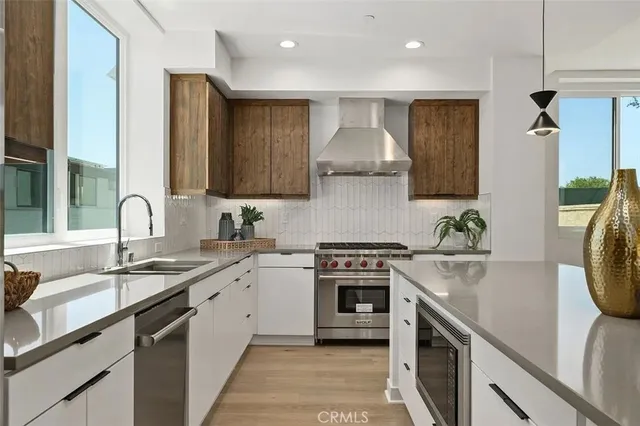 a kitchen with stainless steel appliances granite countertop a sink stove and cabinets