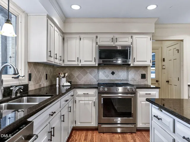 a kitchen with kitchen island granite countertop a sink cabinets and window