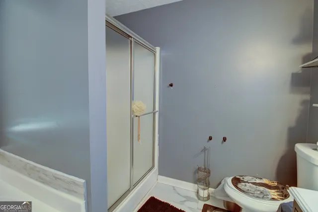 a bathroom with a toilet and a shower