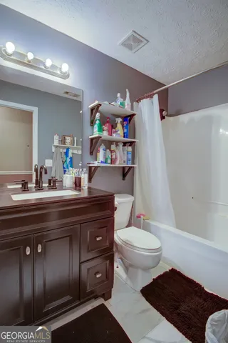 a bathroom with a sink a toilet and a shower