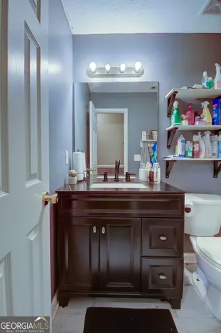 a bathroom with a sink vanity and a toilet