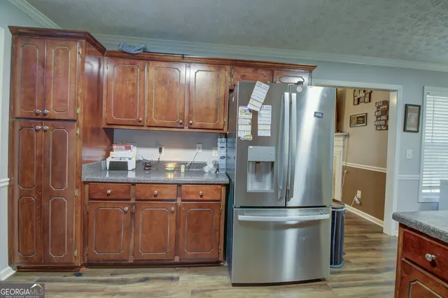 a kitchen with stainless steel appliances granite countertop a refrigerator and a cabinets