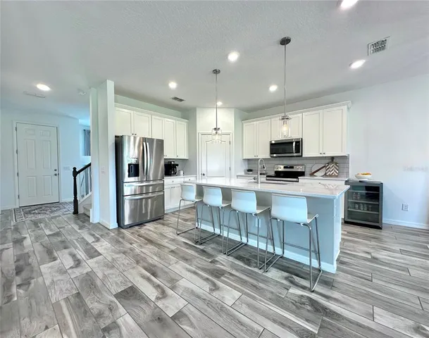 a kitchen with stainless steel appliances a stove a sink a microwave a refrigerator and cabinets