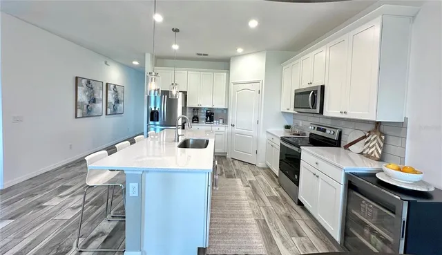 a kitchen with white cabinets appliances and sink