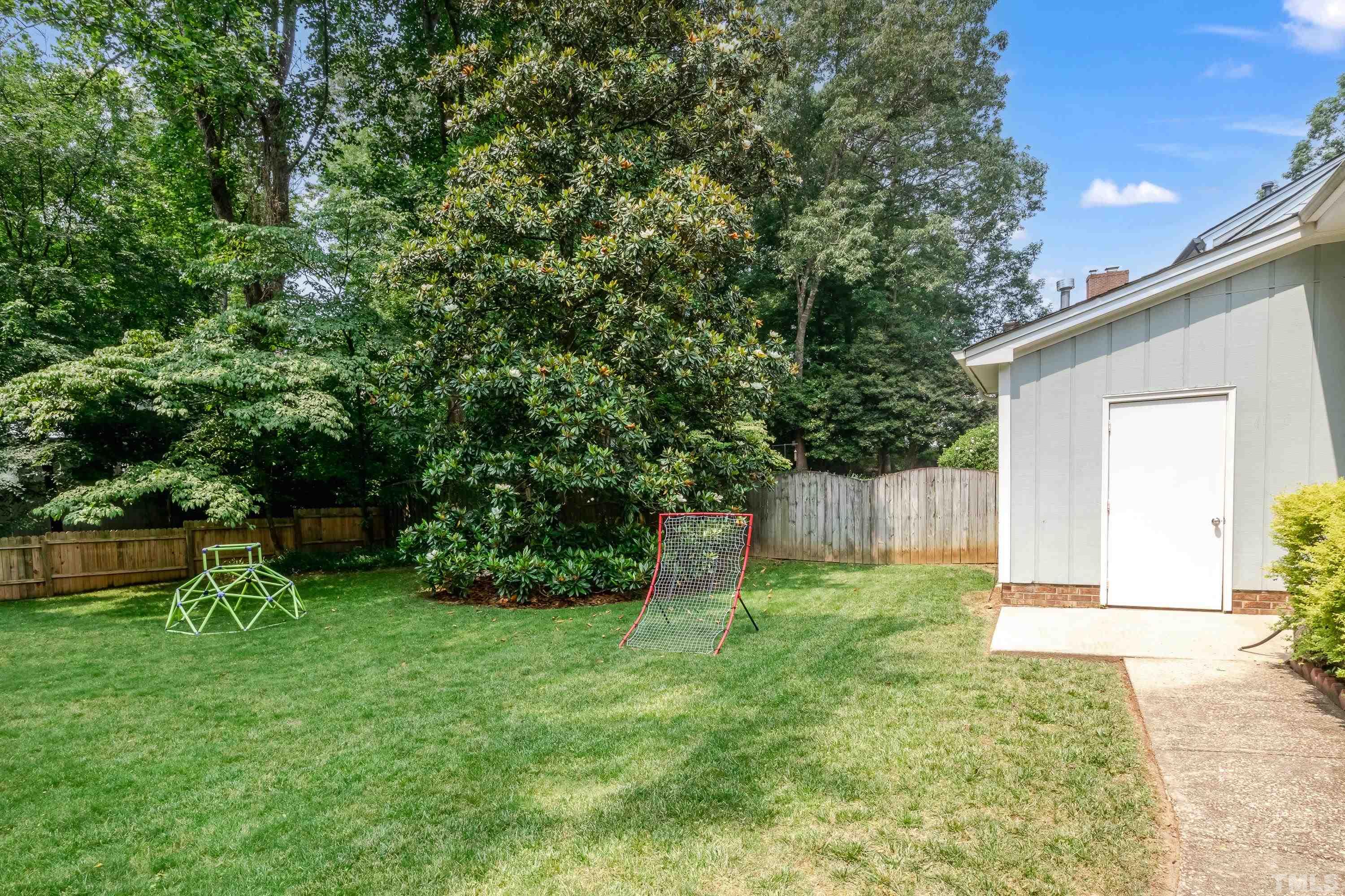 2313 Pastille Lane Raleigh, NC 27612 - Photo 42 of 43 a view of a backyard with potted plants and large tree