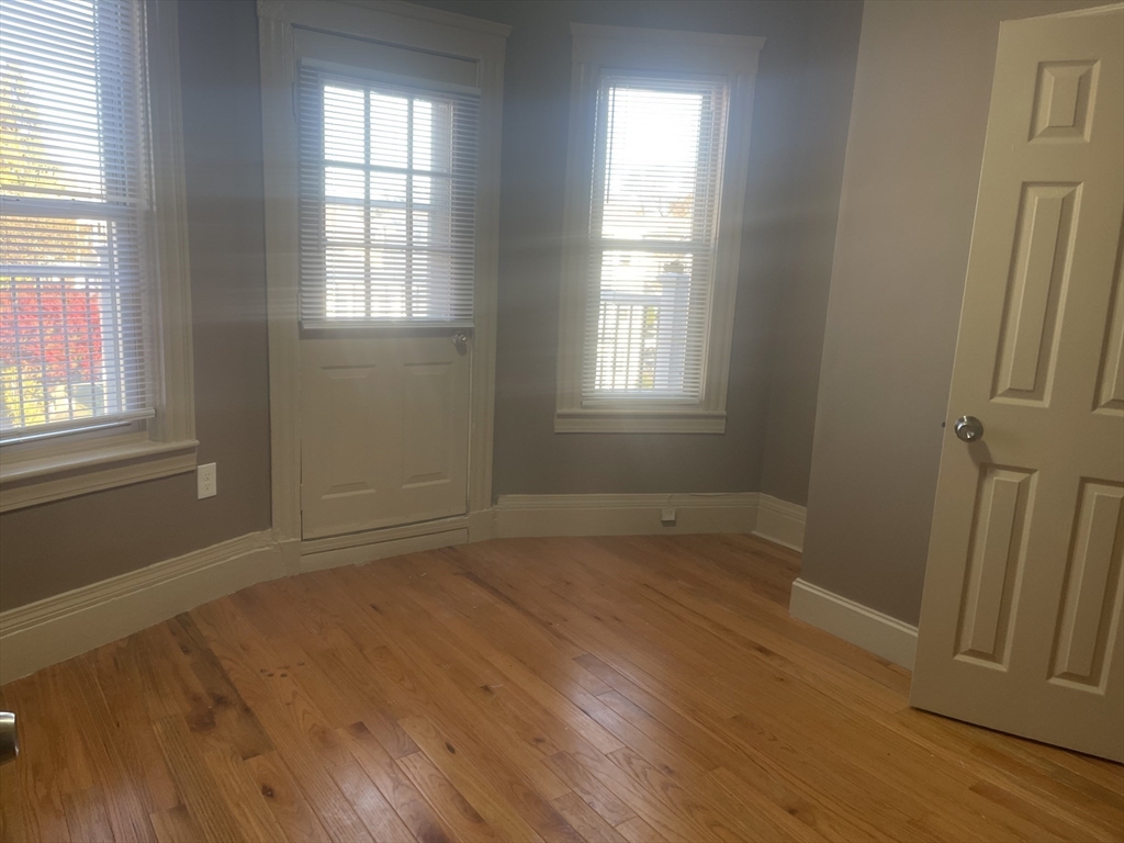 1002 River Street, Unit 3 Boston, MA 02136 - Photo 3 of 11 an empty room with wooden floor and windows
