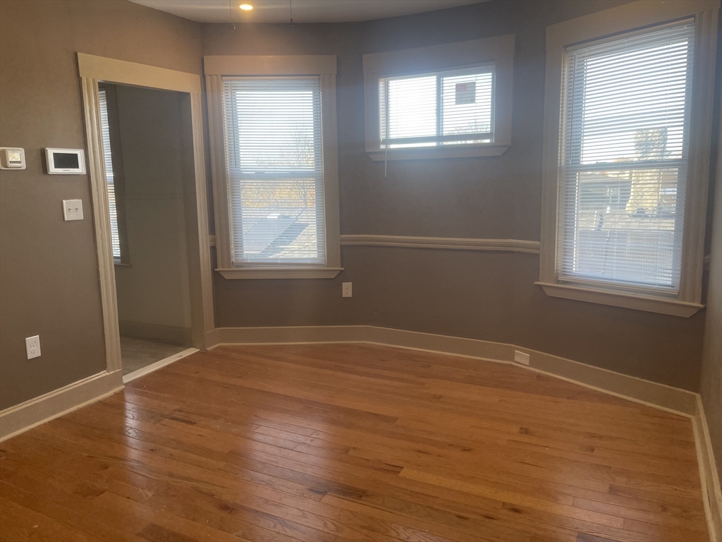 1002 River Street, Unit 3 Boston, MA 02136 - Photo 5 of 11 a view of an empty room with wooden floor and a window