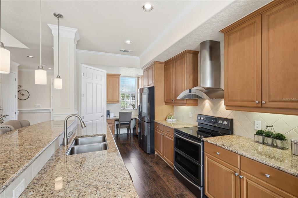 8063 St Simons Street, Unit 8063 University Park, FL 34201 - Photo 7 of 29 a kitchen with granite countertop wooden cabinets and stainless steel appliances