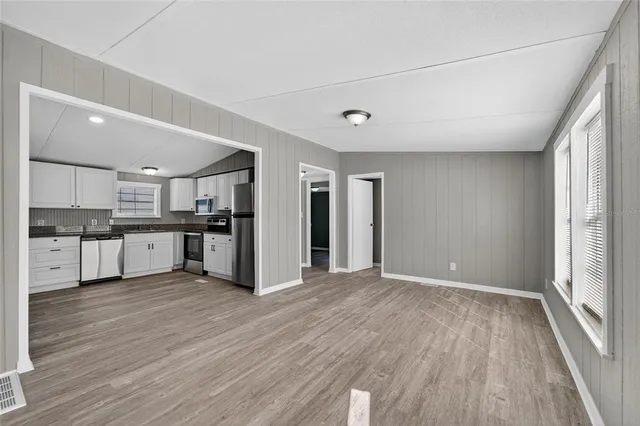 a view of kitchen with wooden floor and electronic appliances
