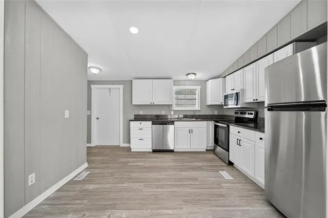 a kitchen with white cabinets and white appliances