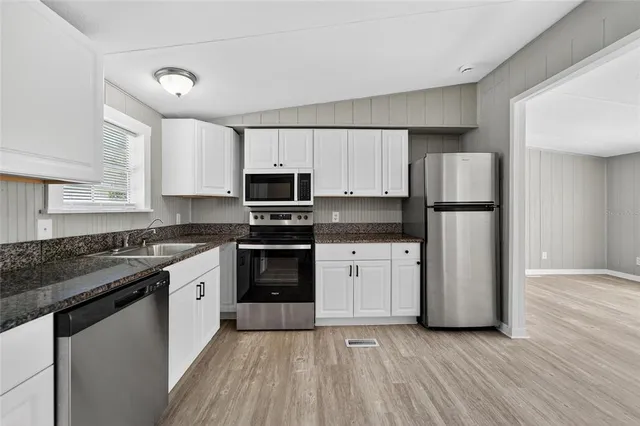 a kitchen with stainless steel appliances granite countertop a refrigerator stove and sink