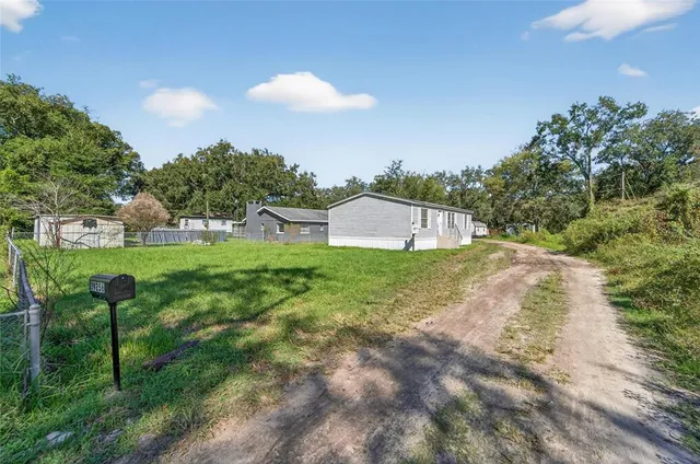 a view of a house with a yard and sitting area