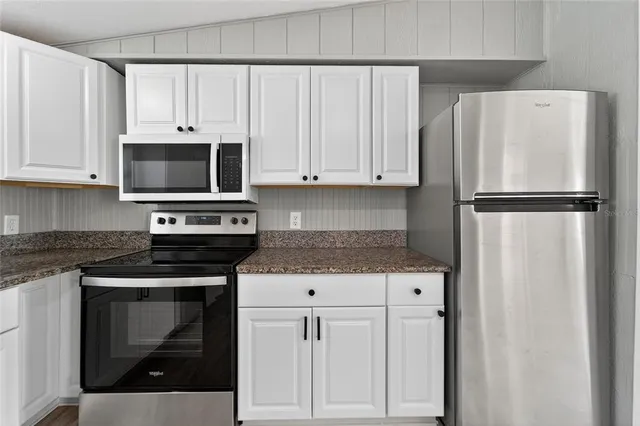 a kitchen with white cabinets and white appliances