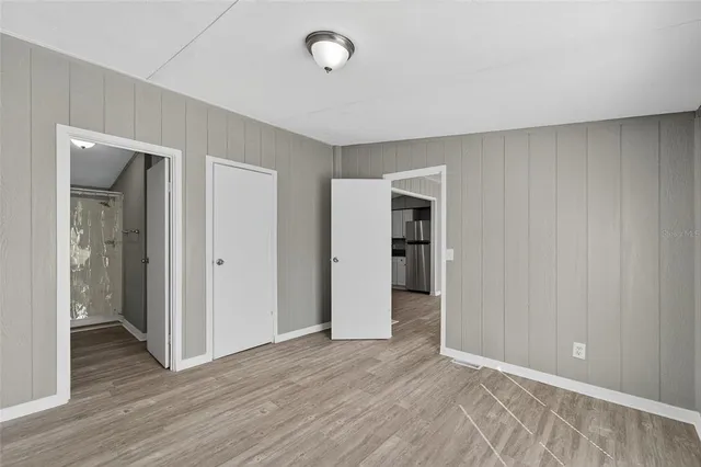 an empty room with closet and wooden floor