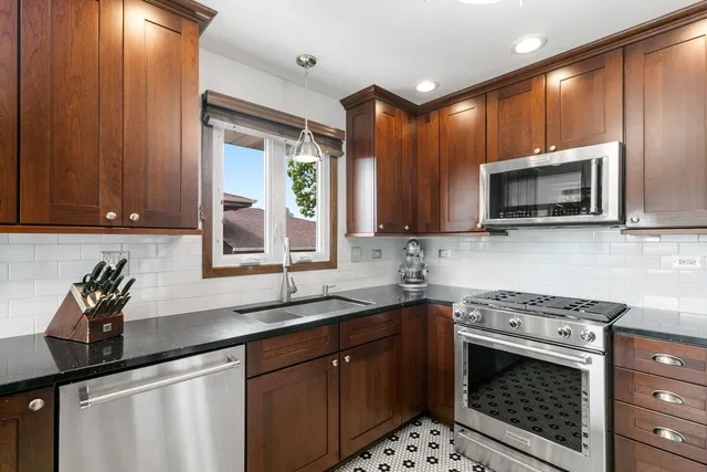 a kitchen with stainless steel appliances a sink stove and microwave