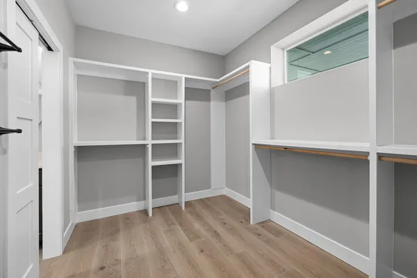 a view of an empty room with closet and a window